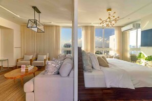 A hotel room with a sofa, a bed, a coffee table, and a view of the city. - Pano360 Studio Downtownsd Rooftop Hottub LUX (Santo Domingo)