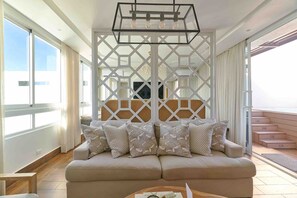A modern living room with a sofa, a coffee table, and a decorative partition. - Pano360 Studio Downtownsd Rooftop Hottub LUX (Santo Domingo)