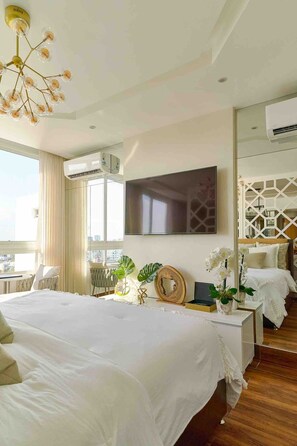 A modern hotel room with a large bed, a TV, a balcony, and a decorative wall panel. - Pano360 Studio Downtownsd Rooftop Hottub LUX (Santo Domingo)
