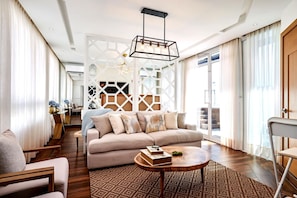 A modern living room with a sofa, coffee table, and a decorative light fixture. - Pano360 Studio Downtownsd Rooftop Hottub LUX (Santo Domingo)