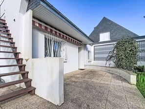 Ein Wohngebäude mit Treppe, geschlossenem Eingang und einem Schotterweg.