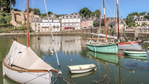 A harbor with several boats docked, a stone bridge, and buildings along the riverbank. - Maison Erdeven by Interhome (Erdeven)