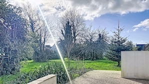 A paved pathway in a garden with a clear sky and sunlight. - Maison Erdeven by Interhome (Erdeven)