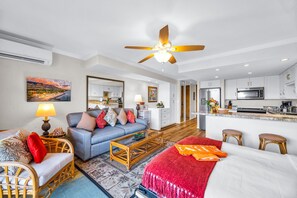 A modern living room with a sofa, coffee table, and a red throw blanket. - Papakea Villas | Ocean View Studio Sleeps 4 | Car Incl. w/ 6+ Nights | PKD-303 by KBM (Lahaina)