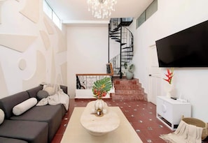 A modern living room with a sofa, coffee table, and a staircase leading to an upper floor. - Bathtub | WIFI | close to Polanco and Chapultepec (Ciudad de México)