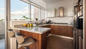A modern kitchen with a large island, wooden cabinets, and a view of the outdoors.