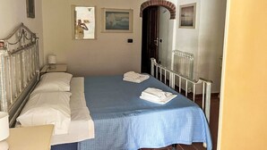 Une chambre à coucher avec un lit, une table de chevet, un miroir et une porte.