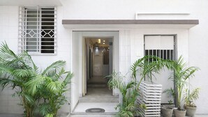 A white building with a door, steps, and potted plants. - Fabhotel Diamond Regency (Kolkata)