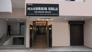 A building entrance with a sign for 'MAHARAJA GOLD THE DREAM VALLEY' and a staircase leading to the entrance.