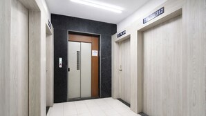 Un couloir avec une porte portant l’inscription « 311 à 312 » et un panneau indiquant « Il est interdit de fumer ».