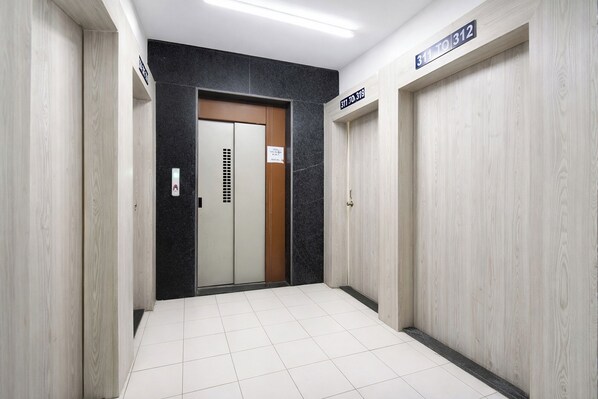 A hallway with a door marked '311 to 312' and a sign indicating 'No Smoking.' - Fabhotel Swapanpurti Sai Avenue (Pune)