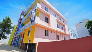 A multi-story hotel with balconies, a sign indicating availability of A/C rooms, and a contact number. - Fabhotel Jay Jaga Residency (Chennai)