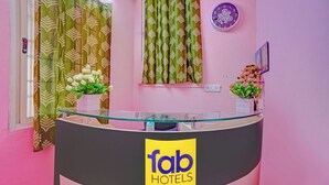 A reception desk with a glass top, a clock, and a sign for 'fab hotels' on the wall. - Fabhotel Jay Jaga Residency (Chennai)
