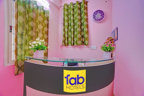 A reception desk with a glass top, a clock, and a sign for 'fab hotels' on the wall. - Fabhotel Jay Jaga Residency (Chennai)