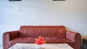 A red sofa with a marble table in front. - Fabhotel Atithi Executive (Pune)