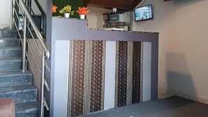 A modern interior with a staircase, a marble table, and a kitchen area with a TV. - Fabhotel Atithi Executive (Pune)