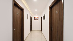 A hallway with wooden doors, numbered 106 and 105, and a framed picture on the wall. - Fabhotel Park View (New Delhi)