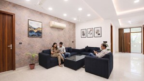 A modern living room with a sectional sofa, a coffee table, and a potted plant. - Fabhotel Park View (New Delhi)