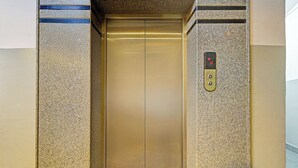 An elevator with a metallic interior and a control panel on the right side. - Fabhotel Rudra Grand (Hyderabad)
