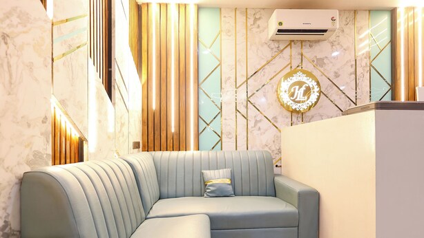 A modern living area with a sectional sofa, a decorative wall with geometric patterns, and an air conditioning unit. - Fabhotel Lorven Grand (Visakhapatnam)