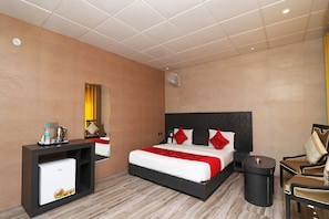 A hotel room with a bed, bedside table, mirror, and a small round table.