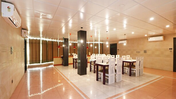 Eine großzügige Hotelhalle mit Empfangsschalter, mehreren Sitzbereichen und Deckenleuchten.