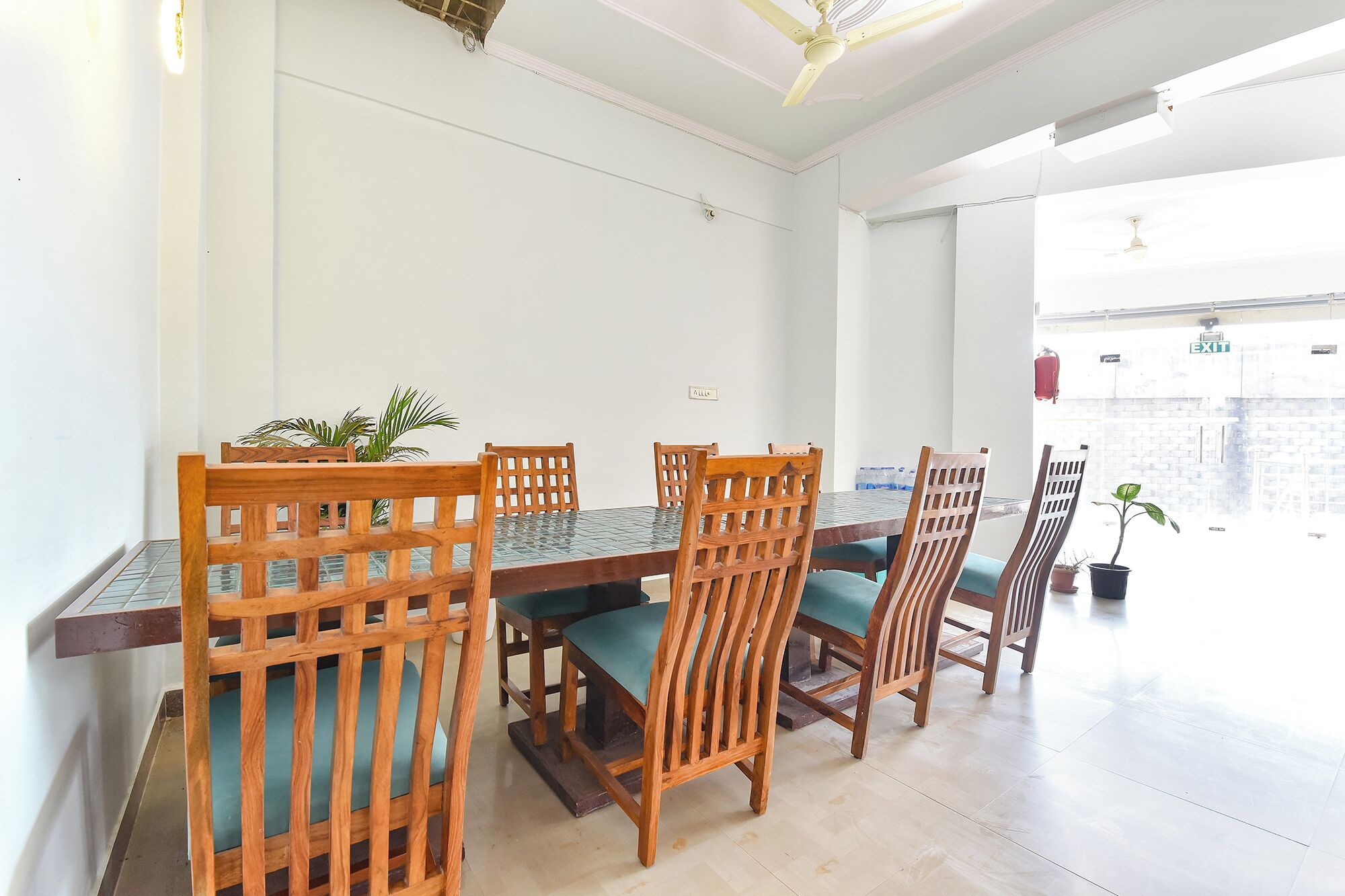 Un espace repas comprenant une table et des chaises, un ventilateur de plafond et une vue sur l’extérieur.