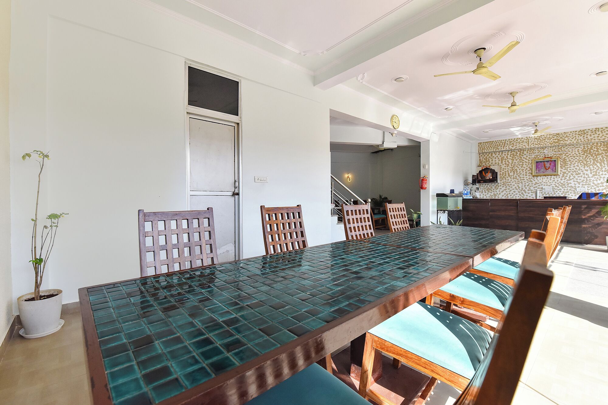 A dining area with a long table, chairs, and ceiling fans.