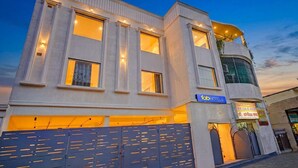 A modern building with a sign for 'fabHOTELS' and a gated entrance. - Fabhotel Symphony Regency (Varanasi)