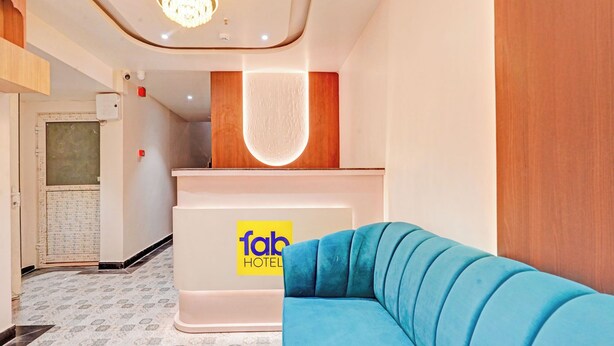 A hotel reception area with a blue sofa, a reception desk, and a patterned floor. - Fabhotel Symphony Regency (Varanasi)