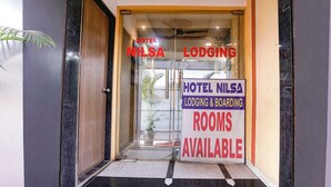 A hotel entrance with a sign indicating 'Hotel Nilsaa Lodging & Boarding Rooms Available.'