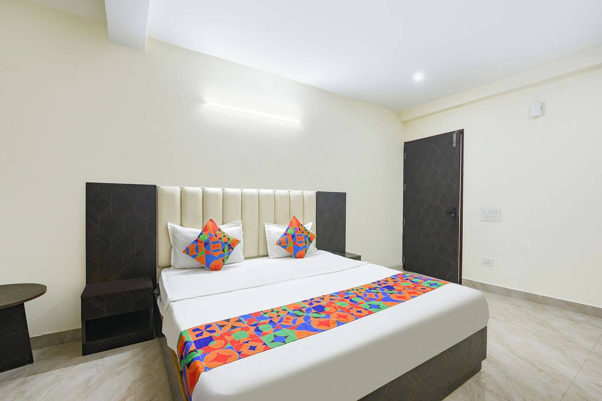 Une chambre d’hôtel comprenant un lit, des tables de chevet, une armoire et un luminaire au plafond.