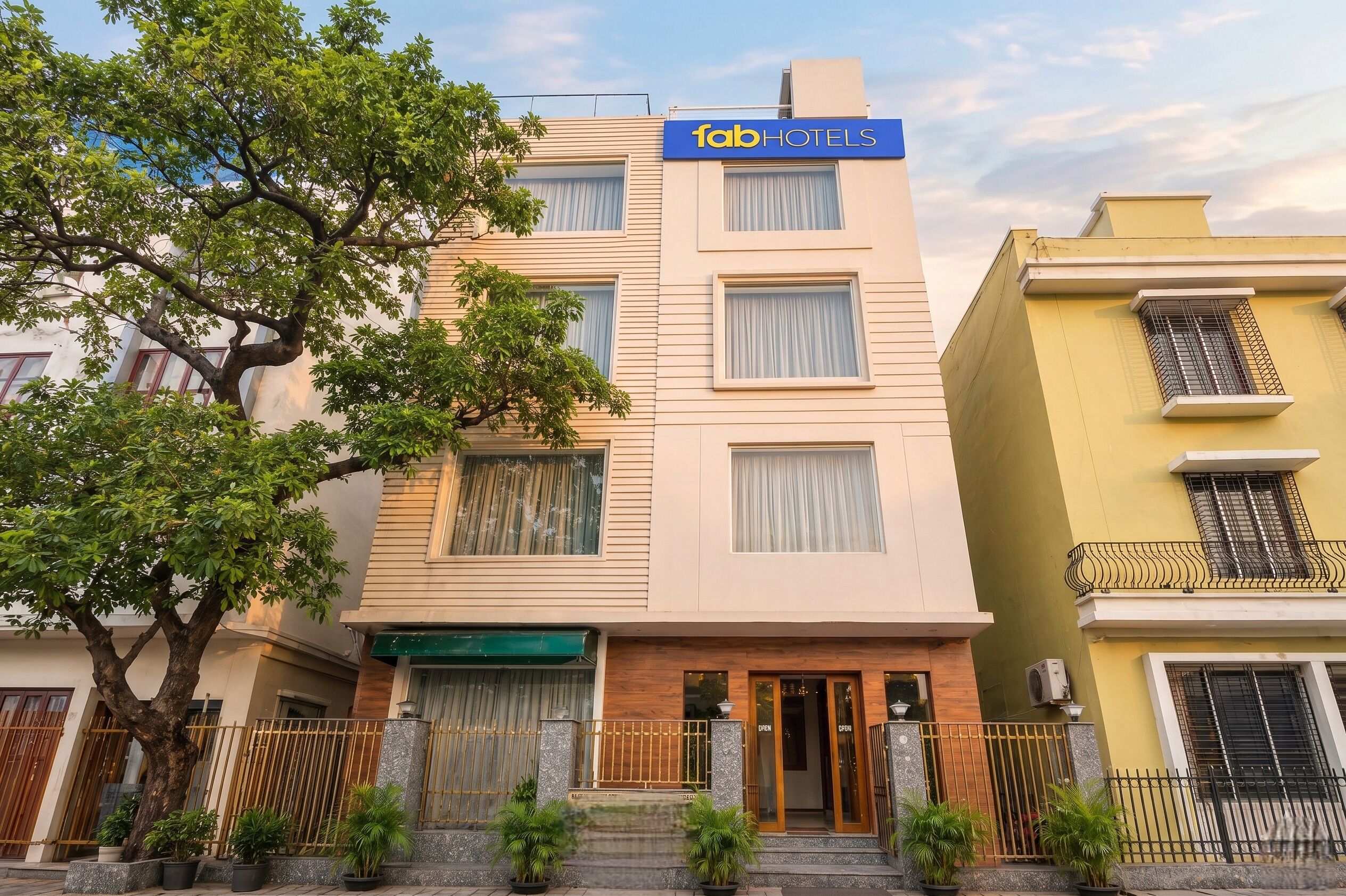 Un edificio de varios pisos con un letrero que dice 'fabHOTELS' en la fachada.