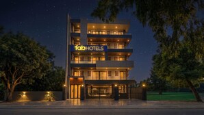 Un hotel de varios pisos con un diseño moderno, que cuenta con balcones y una señalización destacada para 'fabHOTELS'.