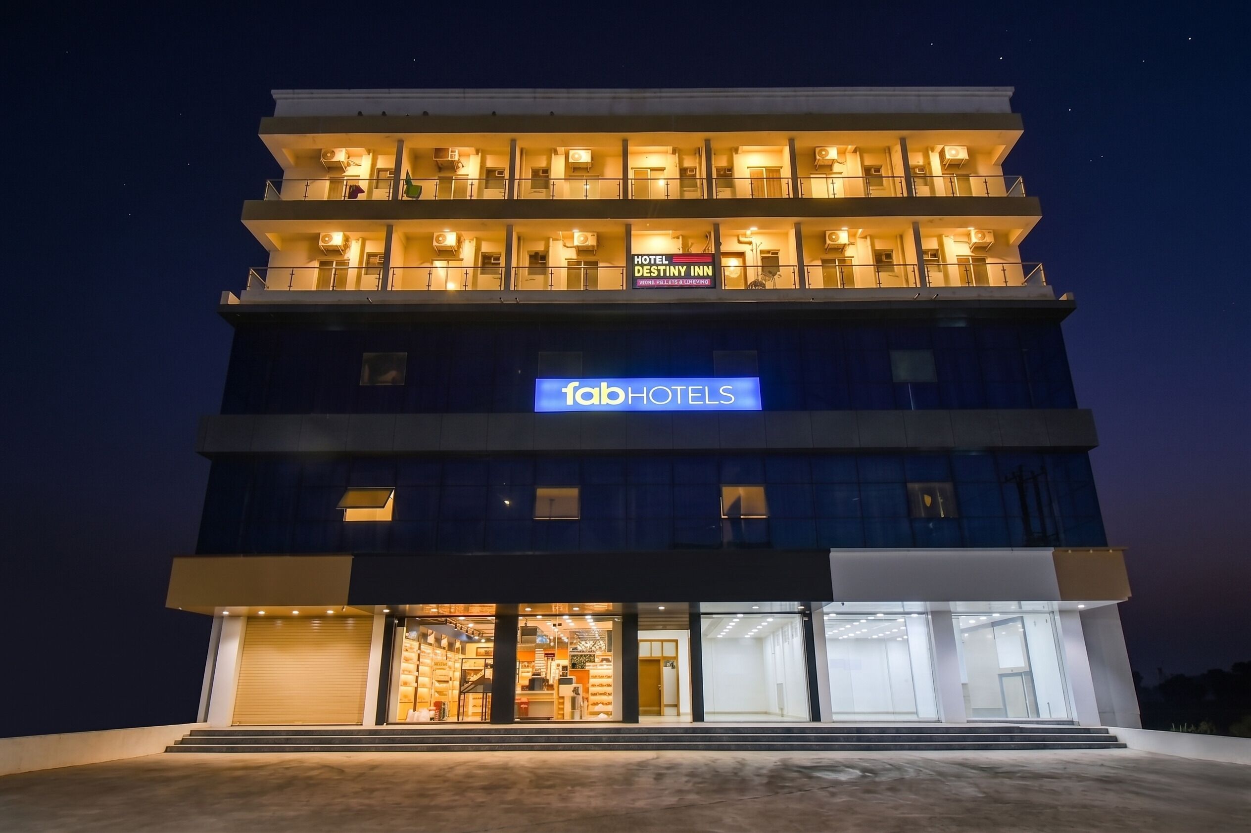 A multi-story hotel with balconies, a visible sign for 'Hotel Destiny Inn,' and a storefront with a sign for 'fabHOTELS.'