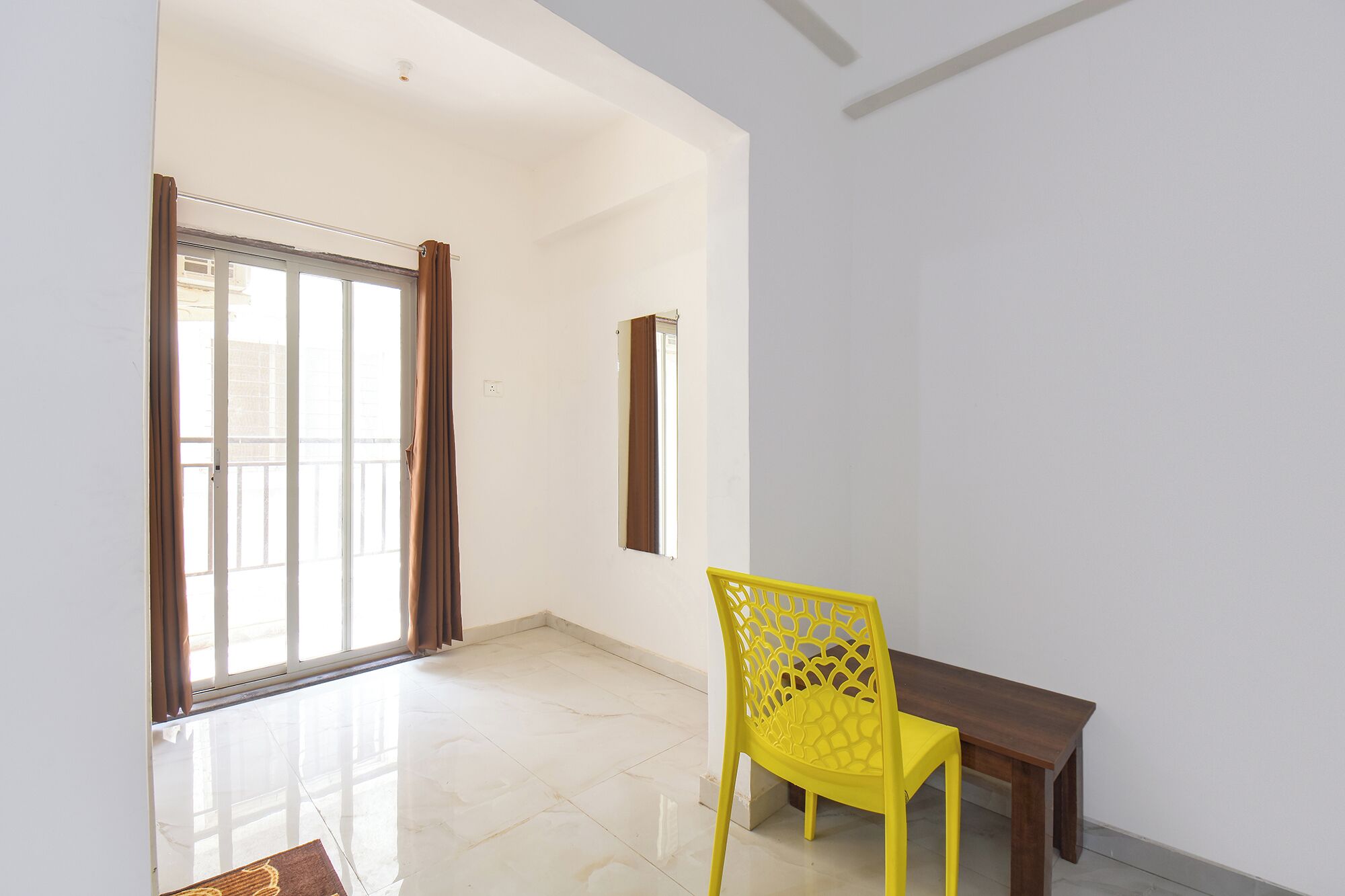 A room with a dining area, a window with curtains, and a tiled floor.
