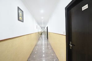 Un couloir avec une porte portant le numéro « 202 » et un tableau encadré accroché au mur.