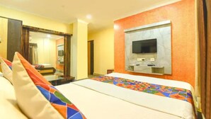 A hotel room with a bed, a television mounted on the wall, and a mirror. - Fabhotel Rainbow Guest House (Kolkata)