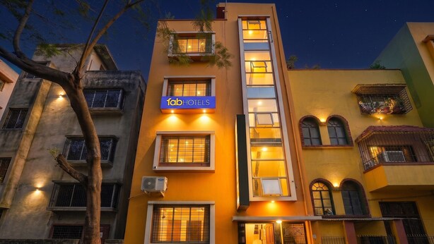 A multi-story building with a sign for 'Fab Hotels' and balconies with plants. - Fabhotel Rainbow Guest House (Kolkata)