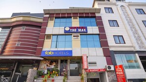 A hotel building with a sign reading 'HOTEL THE MAX' and 'AC BANQUET HALL' visible. - Fabhotel The Max (Lucknow)