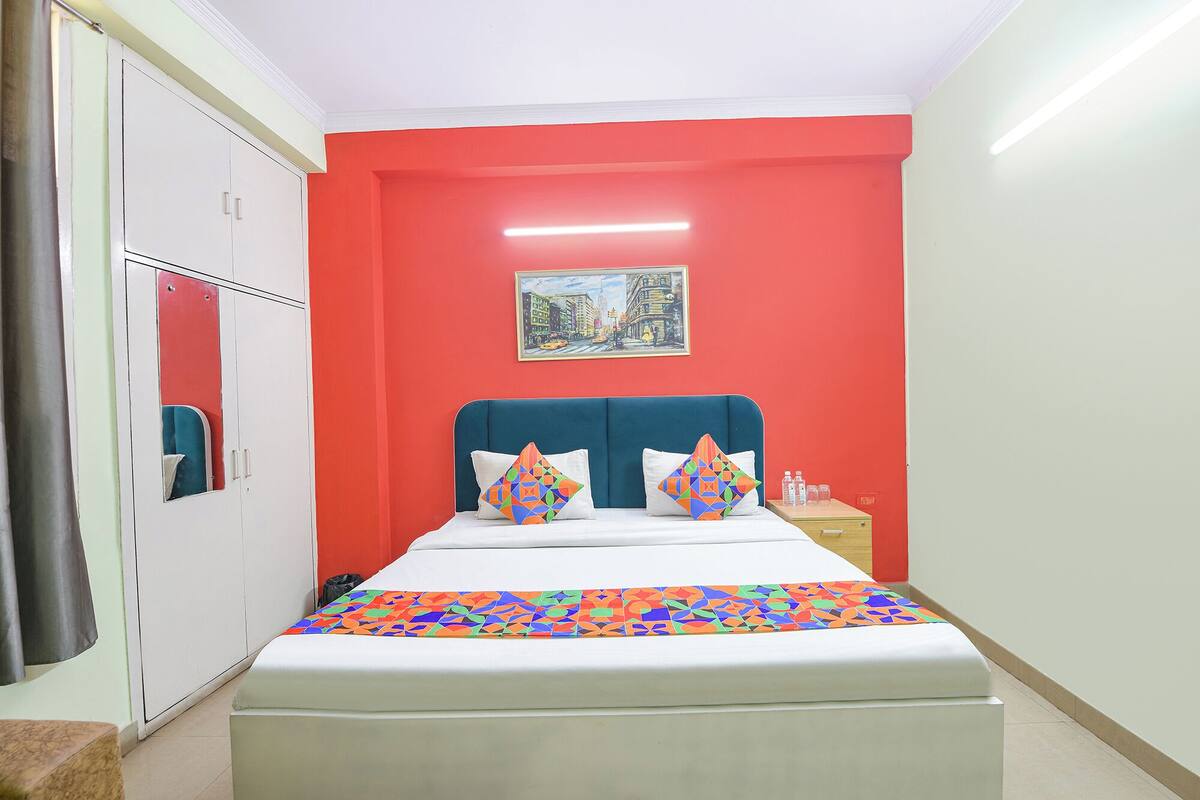 Ein Schlafzimmer mit Bett, Nachttisch, Spiegel und einem Bild an der Wand.