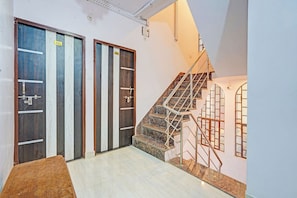 A staircase with metal railings leading to a landing with two doors, each marked with a number. - FabHotel Tirth Comfort Stays - 800 m from Kashi Vishwanath Temple (Varanasi)