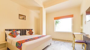 A hotel room with a bed, a chair, a window, and a small desk. - Fabhotel Mansarovar Retreat (Jaipur)
