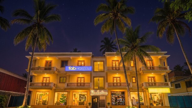 A hotel with multiple balconies, a reception area, and palm trees. - Fabhotel Shadowline (Panaji)