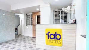 A reception desk with a 'fab hotels' sign, a checkered floor, and a wall-mounted fan. - Fabhotel Krishna Sai (Pune)