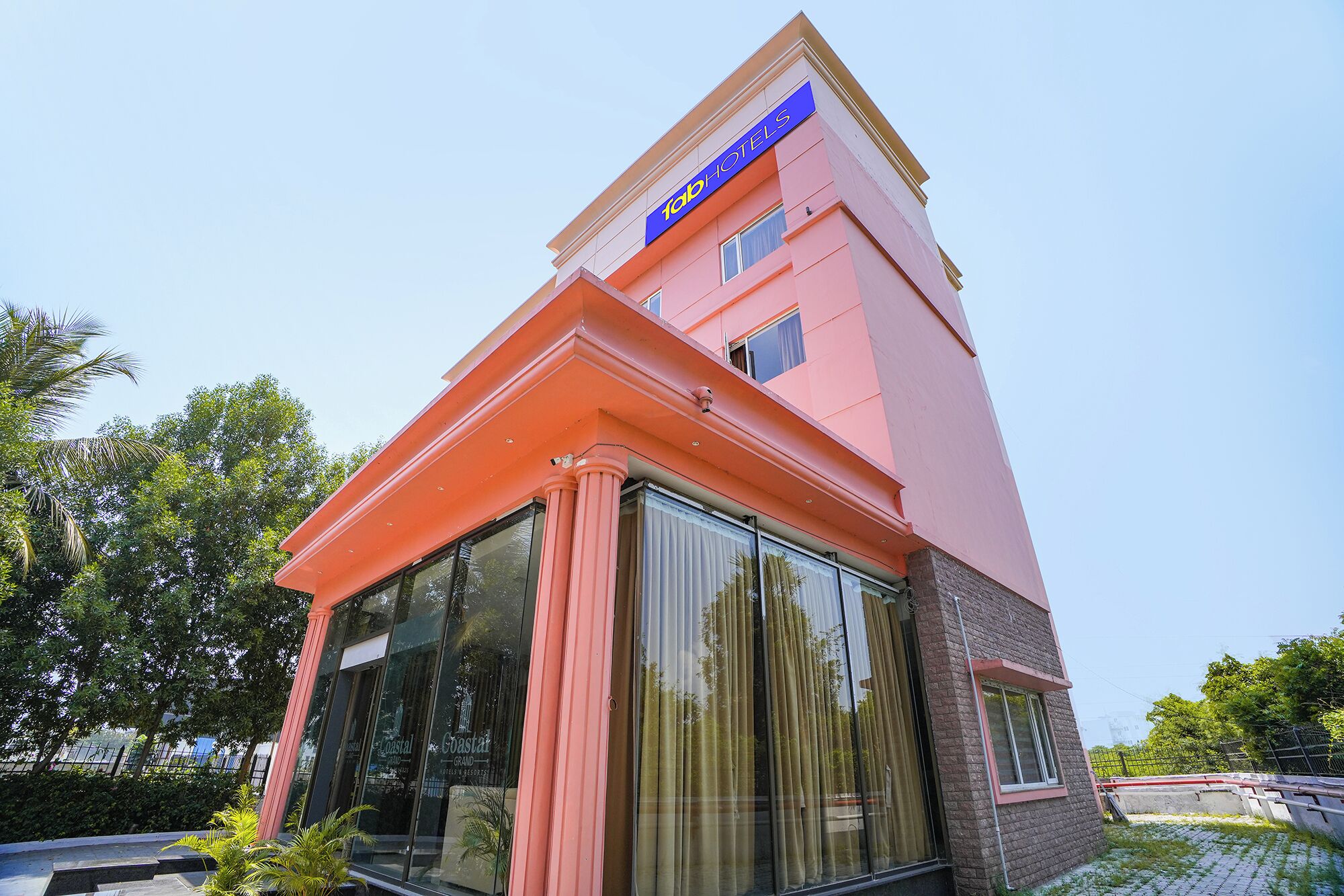A hotel with a modern design, featuring a prominent blue sign at the top.