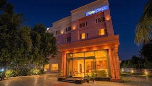 A hotel with a prominent 'Tab Hotels' sign, large glass windows, and a well-lit entrance. - Fabhotel Grand & Resorts (Tirupporur)