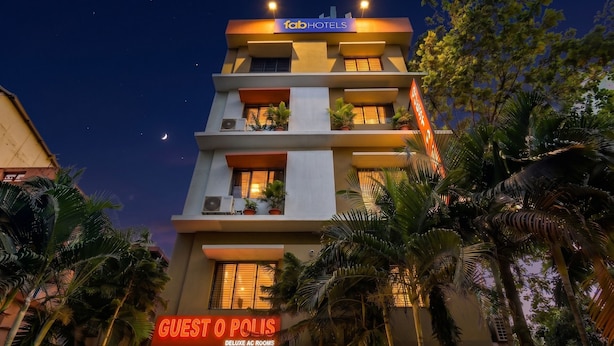 A multi-story building with a sign for 'FabHotels' and 'Guest O Polis Deluxe AC Rooms.' - Fabhotel Guest O Polis Rajdanga (Kolkata)