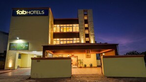 Egy „fabHOTELS” feliratú táblával ellátott szálloda, téglából épült bejárattal és jól megvilágított homlokzattal.