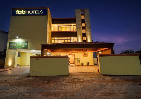 A hotel with a sign reading 'fabHOTELS,' a brick entrance, and a well-lit facade. - Fabhotel Atithi Bhawan (Bhubaneshwar)